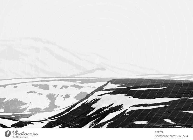 Berge und Hügel auf dem Bergpass Fjardarheidi auf Island Ostisland Nebel düster einsam grau neblig kalt Schnee Einsamkeit Schneereste Landformen Felsen Kälte