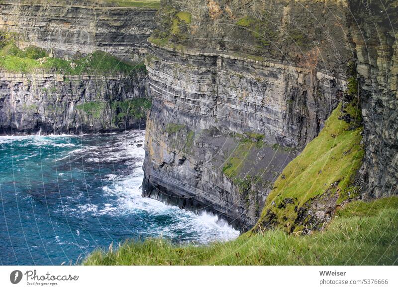 Diese moosbewachsenen Klippen im Meer sind bei Irlandreisenden besonders beliebt Felsen Moos Gestein Brandung Aussicht sonnig Licht wandern Toristen Vögel