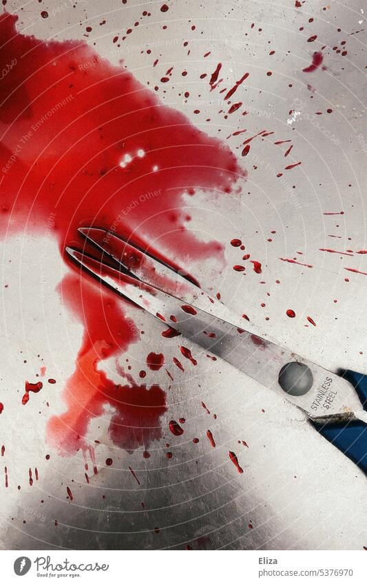 Eine Schere benetzt mit einer roten Flüssigkeit, welches Blut sein könnte, auf Edelstahl. Verletzung Gewalt gefährlich Unfall Waschbecken haushaltsunfall Mord