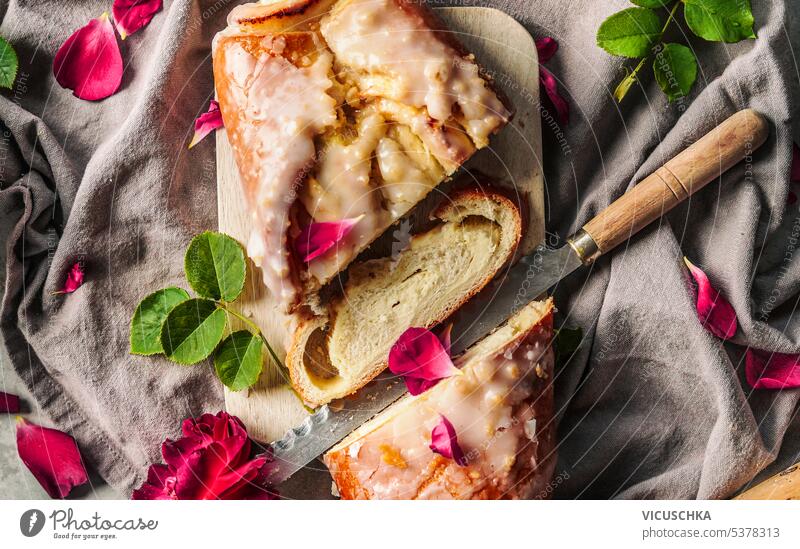 Leckere Käsekuchenrollen mit Messer und Blütenblättern, Ansicht von oben geschmackvoll Pasteten Brötchen Draufsicht Gebäck gebacken rustikal Bäckerei lecker süß