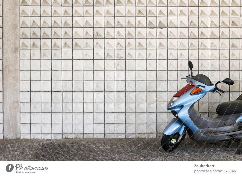 Stahlblauer Motorroller vor gefliester Wand Roller stahlblau Fliesen urban modern Lifestyle Großstadt Verkehr Fahrzeug fahren Freiheit ungebunden parken