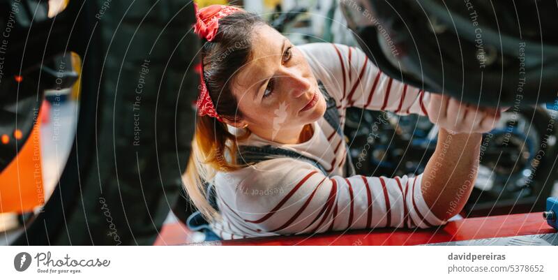 Mechanikerin überprüft Motorrad in der Fabrik Frau Arbeiter Überprüfung überblicken arbeiten Reparatur Transparente Panorama Netz panoramisch Kopfball Porträt