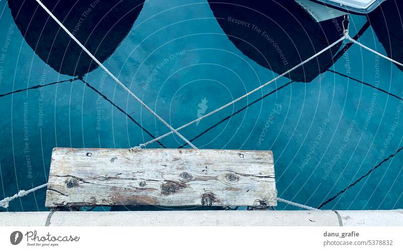 Zwei Boote festgeschnürt am Hafen mit Holzsteg Boote angedockt Wasser Steg Ferien & Urlaub & Reisen Meer blau verschnürt abstrakt angeleint überkreuzt