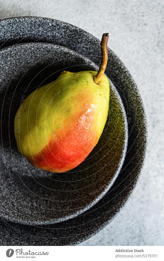 Gesunde Birnenfrüchte in Tellern vor grauem Hintergrund Schalen & Schüsseln Beton Diät Frucht Feinschmecker Gesundheit Ernährung eine nur organisch roh reif