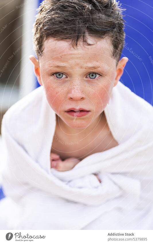 Ernstes Kind sitzend mit Handtuch auf dem Körper Junge verärgert beunruhigt ruhen nasses Haar Liege ohne Hemd Sommer Urlaub Kindheit Park ernst Wochenende