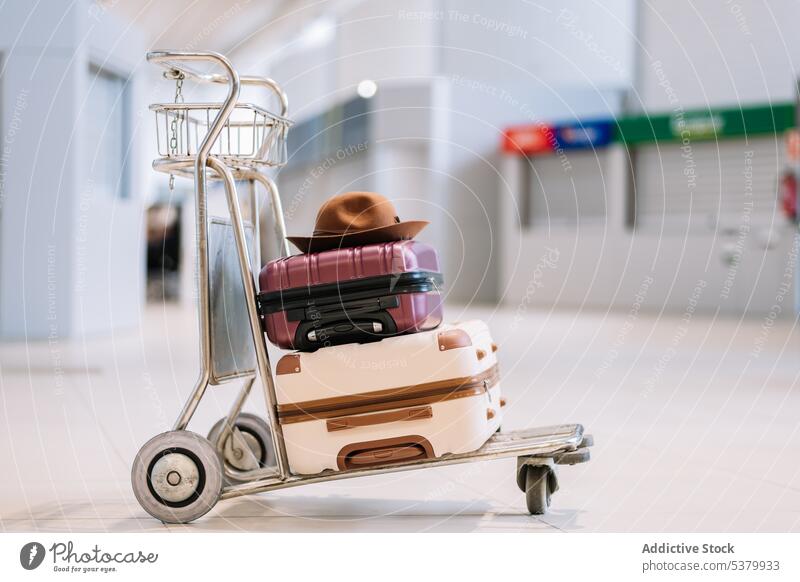 Trolley mit Koffern und Hut im Flughafenterminal Gepäck Ausflug reisen Terminal modern Karre Abheben Urlaub farbenfroh Reise Zeitgenosse Handwagen Feiertag