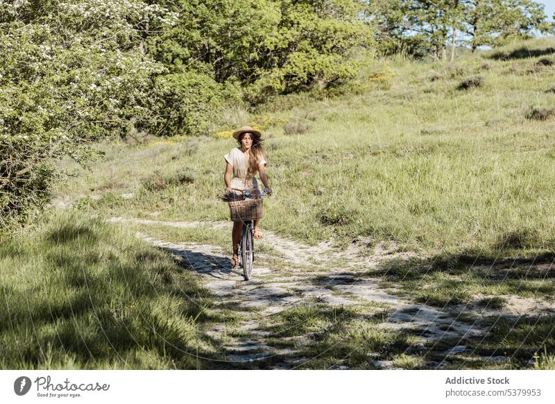 Frau fährt Fahrrad auf dem Lande Landschaft Mitfahrgelegenheit Natur Sommerzeit sorgenfrei Spaß Glück Strohhut gesamt Stil ländlich lange Haare natürlich