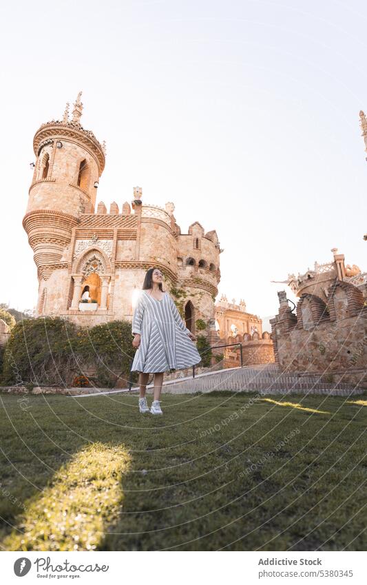 Junge Frau geht im Park in der Nähe des Schlosses spazieren Tourist bewundern Architektur Burg oder Schloss Urlaub Sightseeing Lächeln Rasen historisch jung