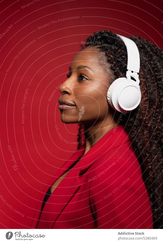 Nachdenkliche Frau, die mit Kopfhörern Musik hört zuhören ernst Drahtlos Stil trendy Melodie positiv schwarz Afroamerikaner Gesang Gerät modern meloman Klang