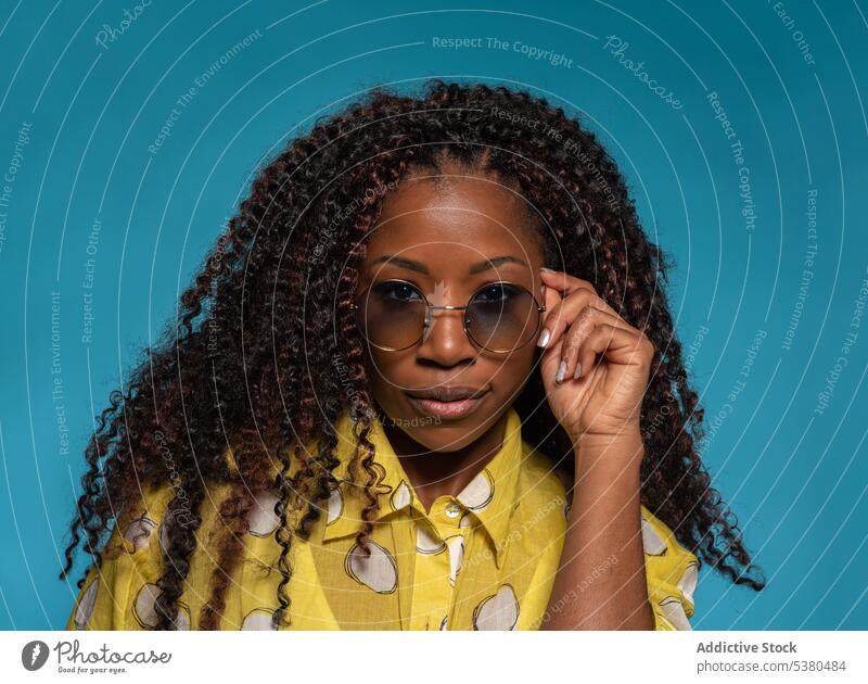 Seriöse stilvolle Frau in trendigem Outfit mit Brille Porträt trendy positiv Mode Frisur Model Stil schwarz Afroamerikaner jung krause Haare Vorschein Dame