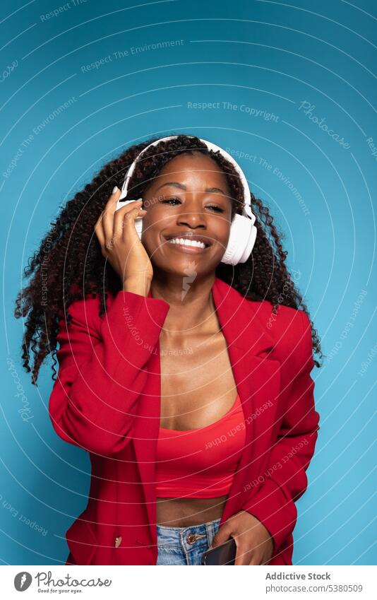 Fröhliche Frau mit Kopfhörern, die Musik hört zuhören Atelier Drahtlos Gesang Stil positiv Audio Afroamerikaner Glück genießen selbstbewusst Lächeln Optimist