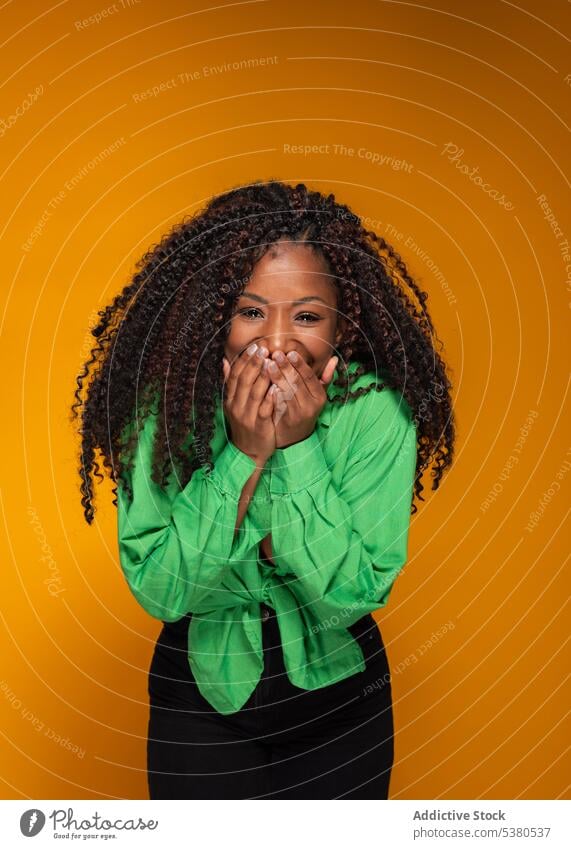 Aufgeregte Frau in grünem Hemd lachend Model Lachen Lächeln aufgeregt begeistert krause Haare dunkles Haar Stil Porträt schwarz Afroamerikaner Witz Humor Freude