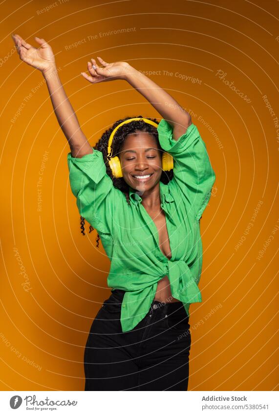 Frau mit Kopfhörern, die Musik hört und tanzt Tanzen zuhören Gesang sich[Akk] entspannen Lächeln heiter schwarz Afroamerikaner Headset Wiedergabeliste Melodie
