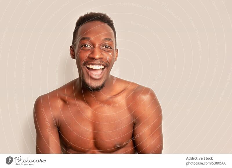 Fröhlicher schwarzer Mann mit nacktem Oberkörper schaut in die Kamera nackter Torso Lächeln Glück ohne Hemd Porträt Model Persönlichkeit heiter positiv