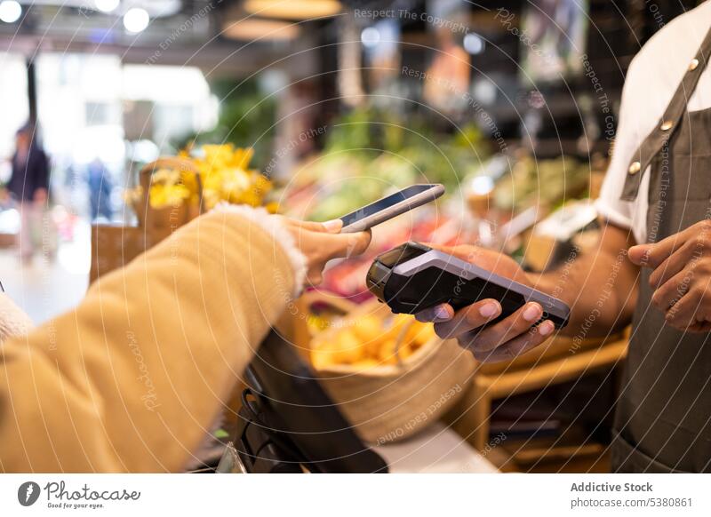 Anonymer Kunde, der mit seinem Smartphone für seine Einkäufe bezahlt Mann Verkäufer berührungslos Terminal Zahlung bezahlen Kauf Transaktion Werkstatt