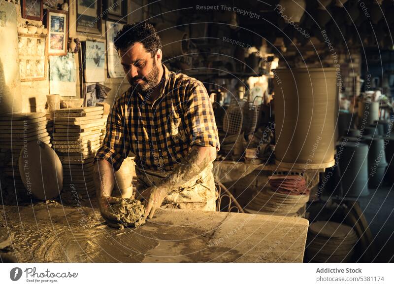 Konzentrierter Handwerker bei der Herstellung eines Tontopfs an der Werkbank in einer Töpferei Mann Werkstatt Töpferwaren Kunstgewerbler Konzentration Arbeit
