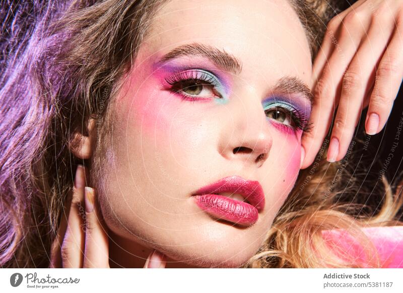 Stylish weibliches Modell mit bunten Make-up berühren Gesicht Frau Porträt 80s Gesicht berühren farbenfroh traumhaft Vorschein sinnlich Angebot jung