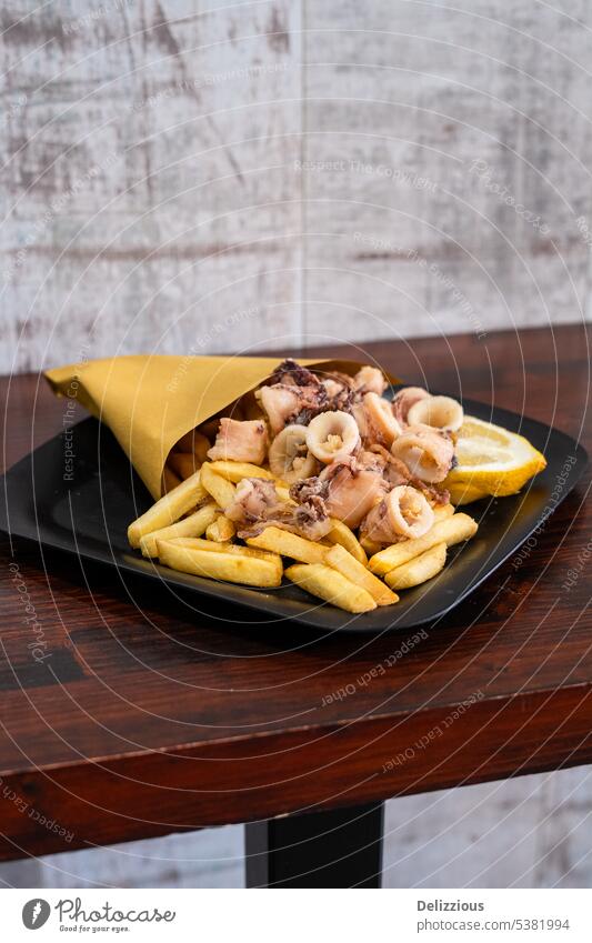 Ein Teller gebratener Tintenfisch mit Pommes frites, oder auf Italienisch: Calamari e patate Kalamari Fries Patate Lebensmittel Tasche Speiselokal Mittagessen