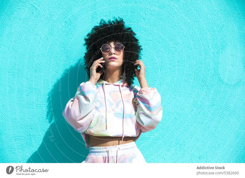 Stilvolle ethnische Frau mit Sonnenbrille, die mit ihrem Smartphone spricht Telefonanruf reden sprechen Gespräch ernst jung hispanisch Mobile Funktelefon