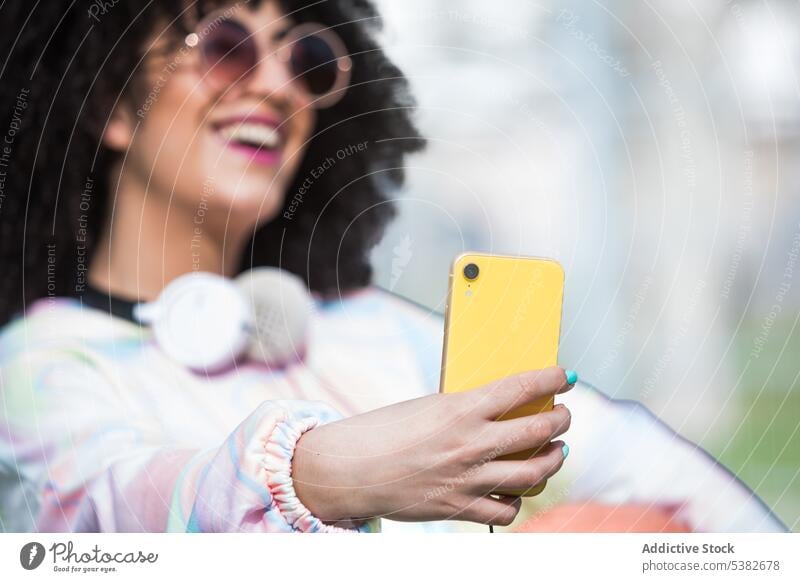 Fröhliche ethnische Frau macht Selfie mit Smartphone Glück heiter Sportpark Zaun Selbstportrait Moment Sommerzeit jung hispanisch positiv Mobile Telefon