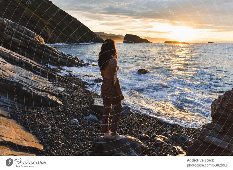 Anonyme Frau bewundert das Meer bei Sonnenuntergang MEER Küste Ufer Strand Natur bewundern Reisender winken felsig Spanien wolkig Wasser Meeresufer Himmel