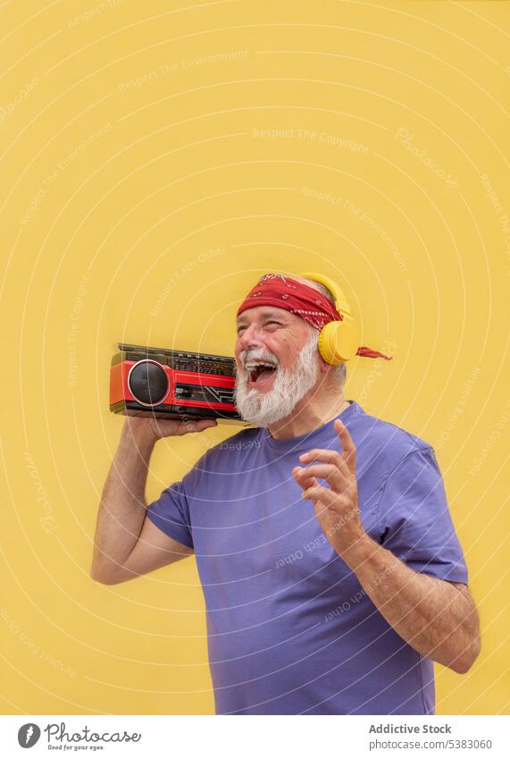 Glücklicher Mann mit Kassettenspieler hört Musik altehrwürdig retro Kopfhörer gealtert männlich positiv Senior Klang Lächeln heiter Rentnerin Audio Vollbart