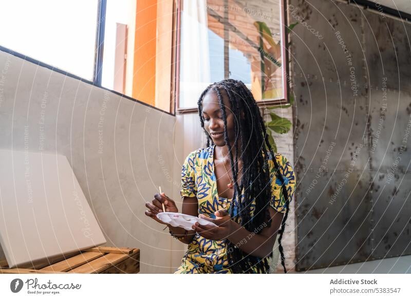 Frau malt mit Aquarellfarben in einem Workshop Anstreicher Farbe Künstler Palette Kunstwerk kreativ Lächeln Fähigkeit Glück Malerei Pinselblume Afroamerikaner