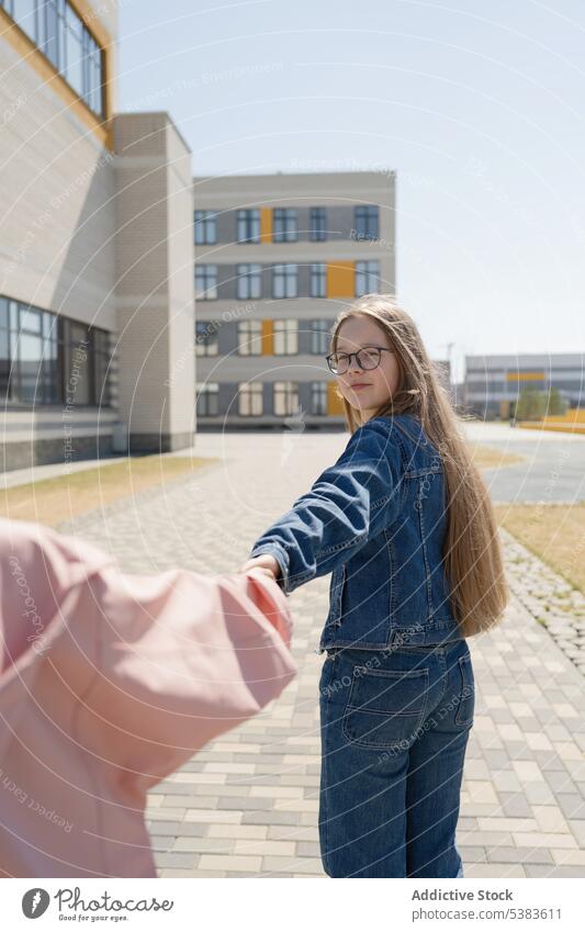 Mädchen hält Hand eines Freundes auf dem Bürgersteig in der Stadt Händchenhalten Teenager Spaziergang Bonden Zusammensein positiv schlendern sorgenfrei jung