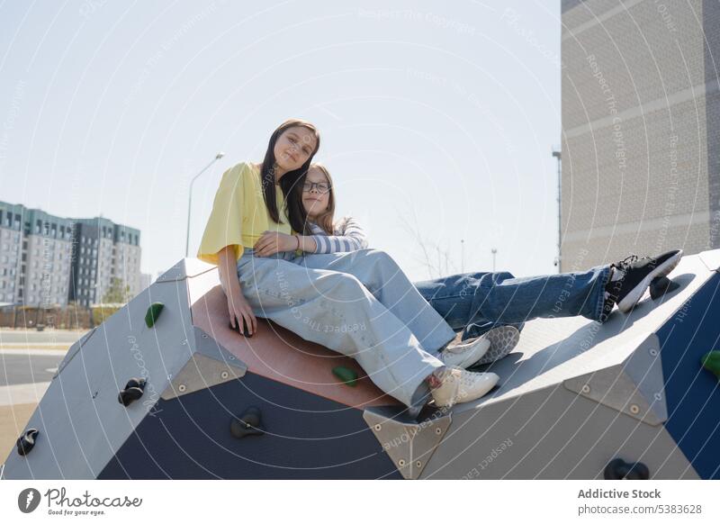 Jugendliche Freunde verbringen ihre Freizeit im Stadtpark Mädchen Teenager sich[Akk] entspannen Lächeln Zusammensein Aufstieg Wand Struktur Park Großstadt