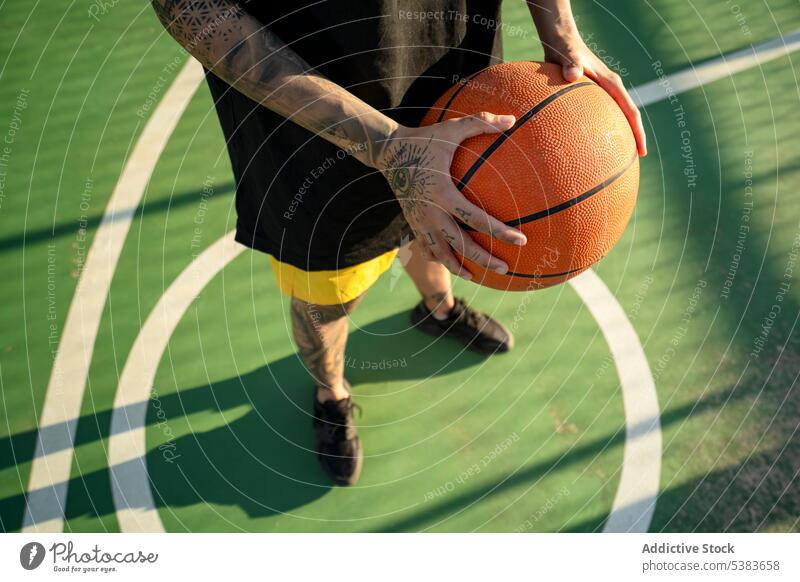 Unbekannte Person mit Basketball auf dem Spielfeld Spieler Ball Sportpark spielen Streetball Gericht Spielplatz Training Sportbekleidung Sonnenschein passen