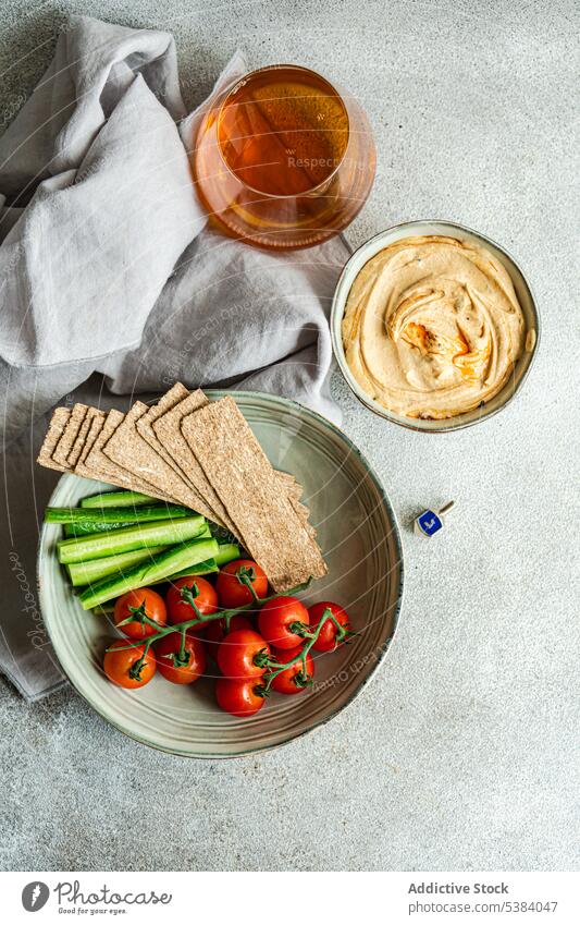 Hummus und Gemüse in einer Schüssel mit einem Glas Schnaps serviert Brotstange Kirschtomate Küche Abendessen Speise Lebensmittel Gesundheit hebräisch Israel