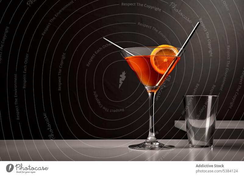 Generative AI Illustration von Glas mit Alkohol Getränk auf grau gegen Tisch in der Nähe von leeren Glas gegen schwarzen Hintergrund mit Strohhalm platziert