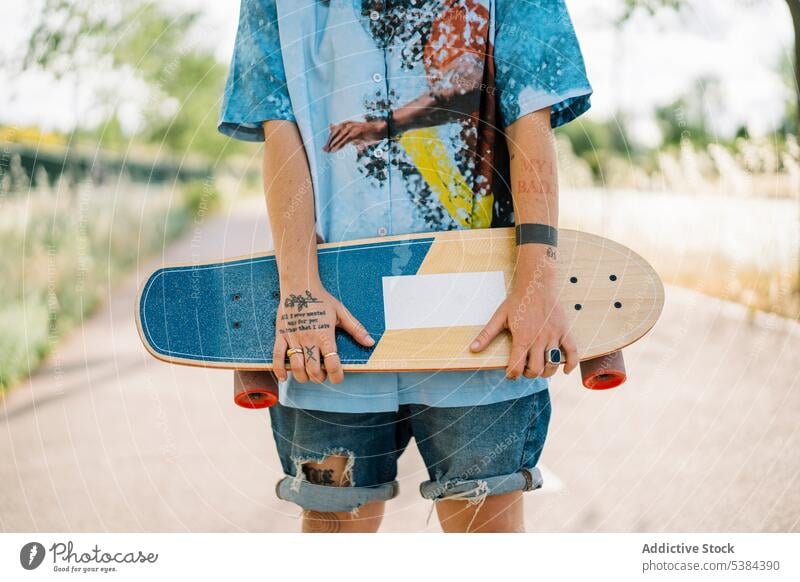 Anonymer schüchterner Junge mit Skateboard im Park Frau anonym Wildfang Straße androgyn Skater lässig trendy jung Stolz cool modern Optimist zufrieden stehen