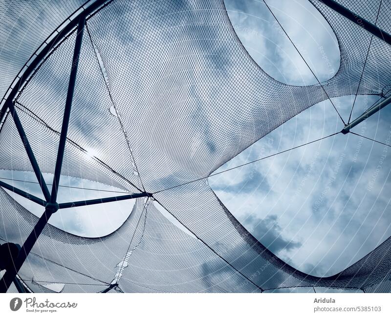 Froschperspektive | durchlöchertes Netz vor blauem Himmel mit Wolken Löcher Durchblick Blauer Himmel Außenaufnahme Licht Sonnenlicht kaputt Gebäude Stahlträger