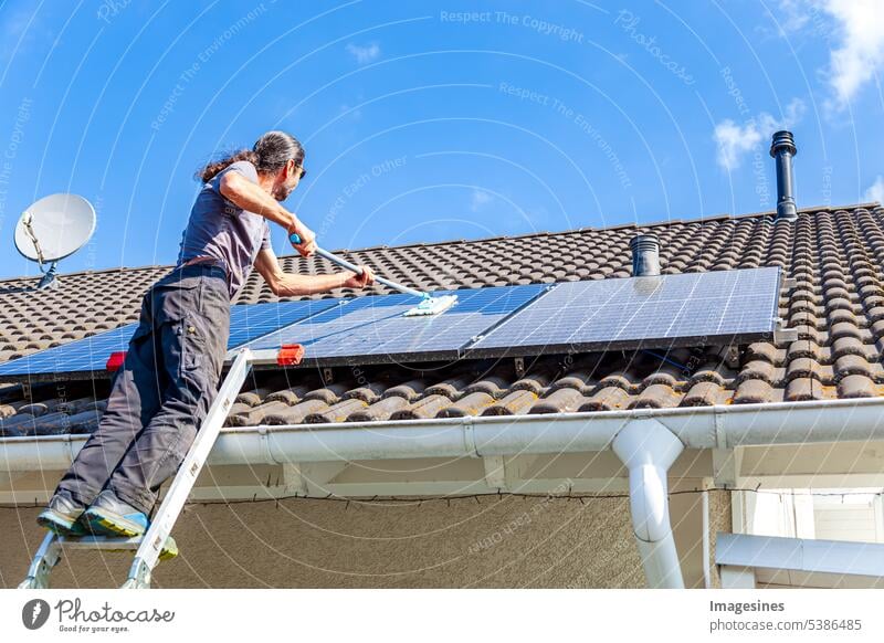 balkonkraftwerk reinigen mit Mop Mann Wischmopp Sonnenkollektoren Reinigung Solarmodule Wasser Nahaufnahme Dach sonnig Himmel Waschen Sommer Saison Tag Haus