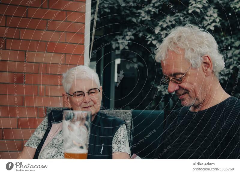 Mainfux | gemütliches Beisammensein Senior Rentnerin graues Haar Brille konzentriert Smartphone Frau grauhaarig Freude Mann Lächeln in den Ruhestand getreten