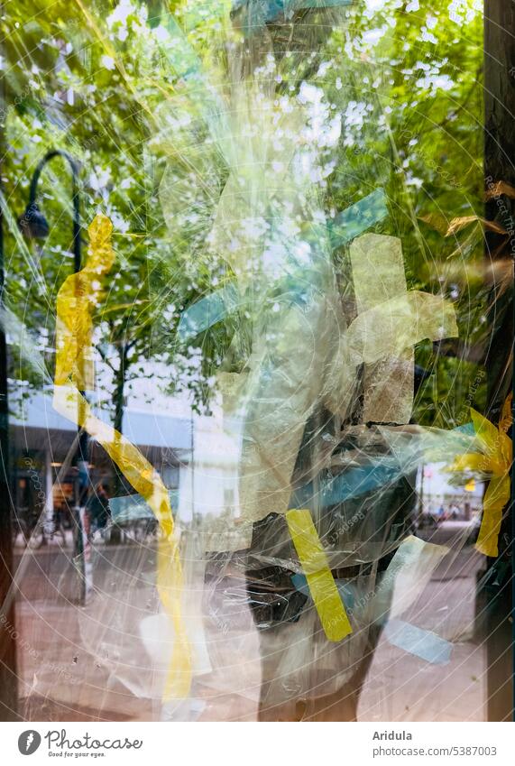 Fußgängerzone spiegelt sich im leeren Schaufenster, das mit Folien und Klebestreifen  von innen verdeckt ist Stadt Glas Fenster Spiegelung Bäume Pflastersteine