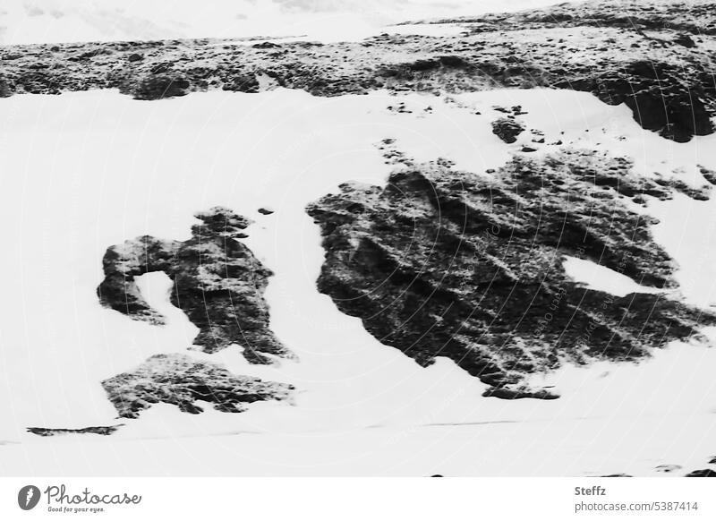 besondere Felsformationen im Schnee auf Island isländisch Bergseite Hügelseite Formen Felsformen bizarr mysteriös abstrakt außergewöhnlich Schneeformen Figuren