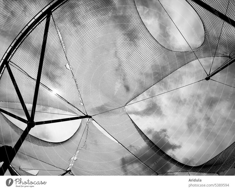 Froschperspektive | durchlöchertes Netz vor Himmel mit Wolken s/w Hinmel Stahlträger Löcher Netzwerk Außenaufnahme Strukturen & Formen Sicherheit Metall Muster