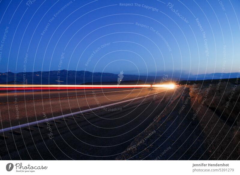 Langzeitbelichtung auf einer Autobahn in der Dämmerung Nachthimmel Schnellstraße Fernstraße Rollfeld streifen Beleuchtung Sonnenuntergang Illumination Nachlauf