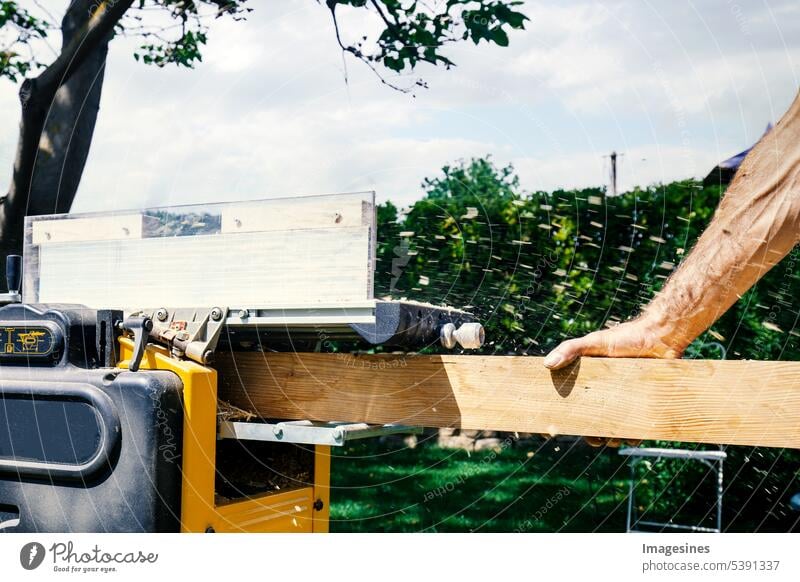 Schreiner arbeitet mit Elektrohobel an Holzbalken, Planke. DIY-Konzept Tischler Männerhand schleifen Holzbrett Garten arbeiten Hobel ausrüstung arbeitsplatz