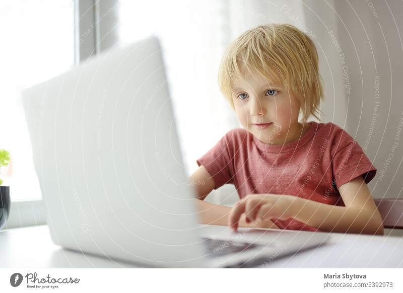 Schuljunge verwenden Computer-App für Studie von Laptop zu Hause. Kind und Gadgets. Online-Bildung und Fernunterricht für Kinder online Schüler Lektion Schule
