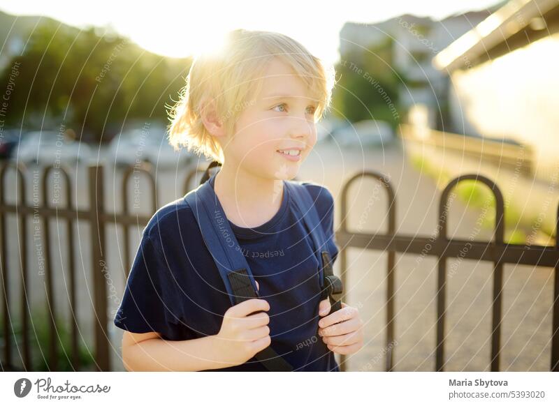 Porträt von niedlichen preteen Junge in der Stadt bei Sonnenuntergang. Glückliches Kind geht zur Schule. Kinder zurück zur Schule Straße positiv Schüler