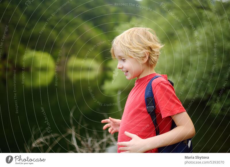 Schulkind wandert und erkundet die Natur im Wald. Preteen Junge Reise in Waldgebiet. Sommerferien Aktivität für wissbegierige Kinder in Parkland. Abenteuer, Scouting, Tourismus für Kinder