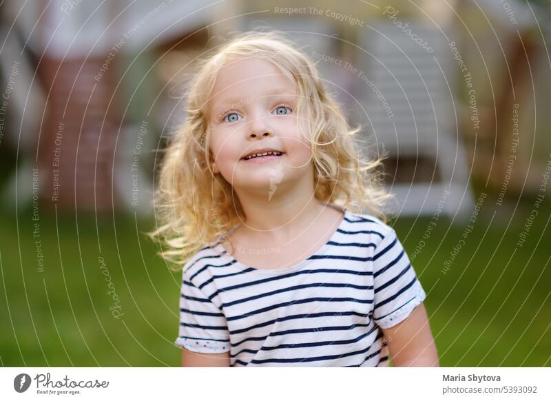 Nettes Kleinkind Mädchen im Freien Porträt im Sommer Tag. Lächelnd und charmant Kind. Baby Verhalten blond blau Windstille Kaukasier Charakter Kindheit konform