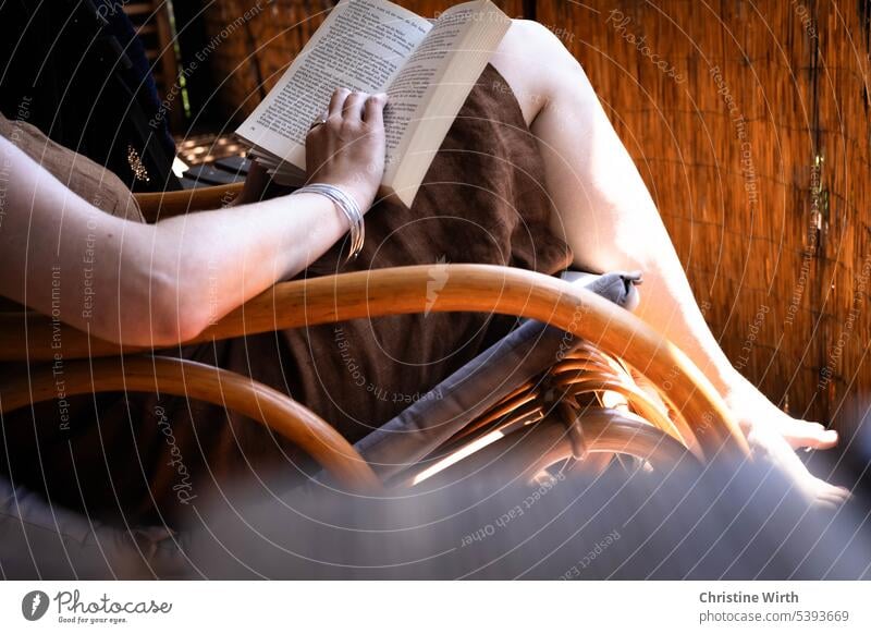 Ein Buch lesen schmökern Schaukelstuhl Frau Literatur Lesestoff Buchseite lernen Sommertag entspannen Roman gemütlich Balkon vertieft Ruhe Bildung