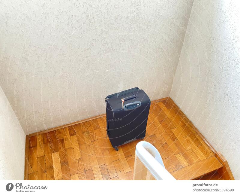 Da hat wohl wer einen schwarzen Rollkoffer in einem Treppenhaus stehen lassen. Foto: Alexander Hauk Koffer reisen urlaub treppen treppenhaus geländer braun weiß
