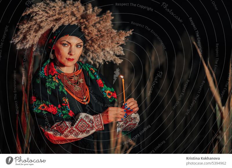 Mysteriöse ukrainische Frau mit Kerze, sie in Tracht im Freien attraktiv schön Schönheit Kleidung selbstbewusst Kultur besticktes Hemd Stickereien ethnisch