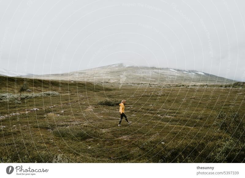 Frau läuft durch Mooslandschaft Norwegen Norwegenurlaub gelbe Jacke spazieren mensch und natur Moosteppich moosbedeckt moosbewachsen Berge u. Gebirge Steine