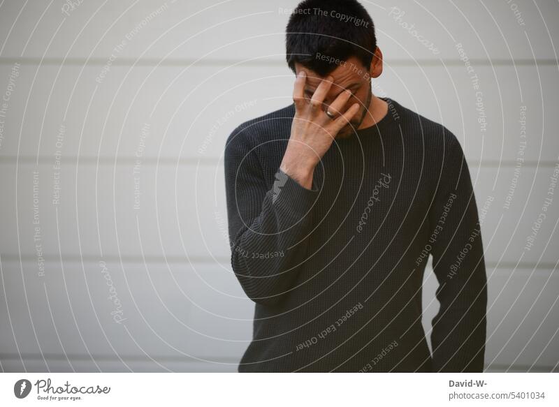 Kopfzerbrechen - genervter Mann hält sich die Hand vor das Gesicht kopfzerbrechen Kopfschmerzen frust migräne Stress Verzweiflung Schmerz Ängste neutral